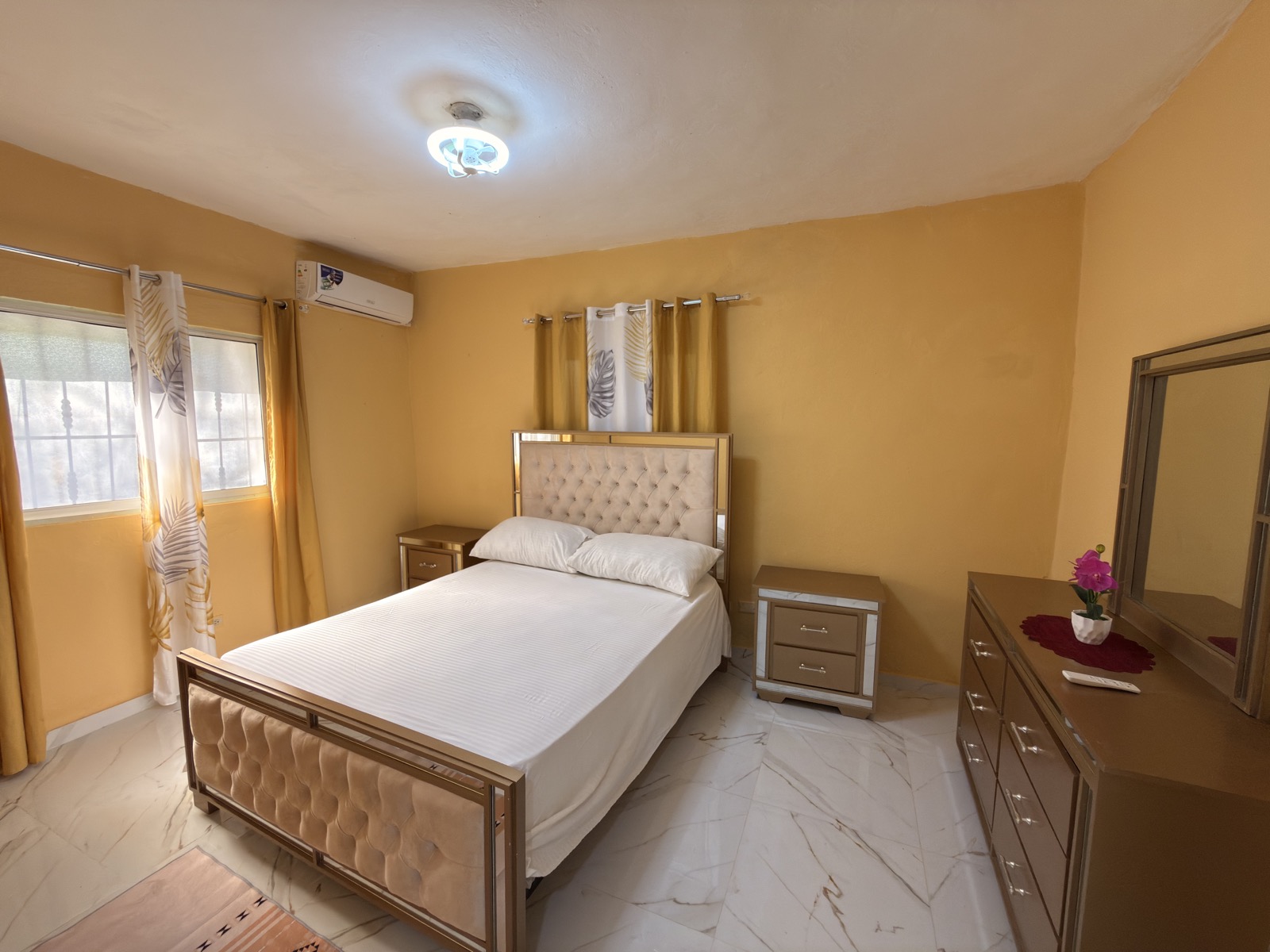Tropical Family Flat — spacious bedroom with warm decor