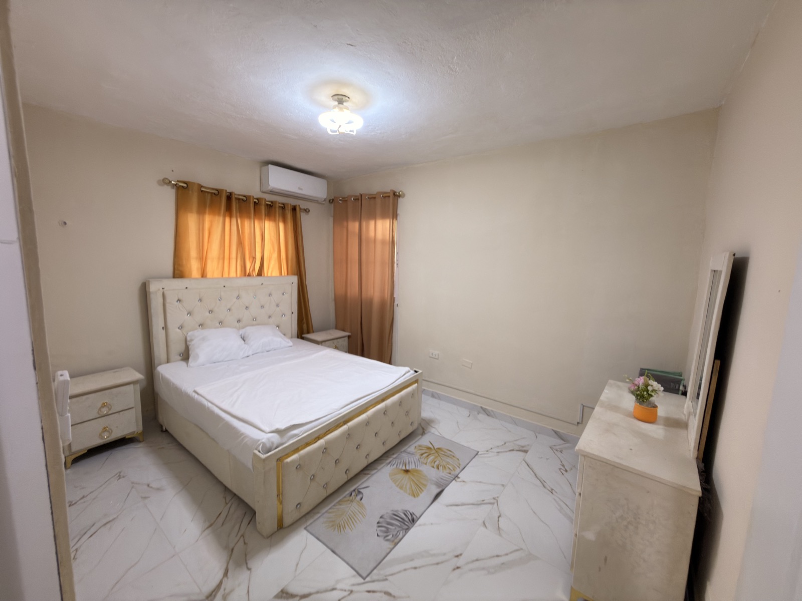 Tropical Family Flat — elegant bedroom with gold headboard